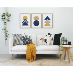 Scandi style cushions and wall art with a mustard throw on a white sofa