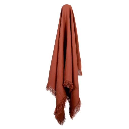 A terracotta linen throw gracefully drapes from a hook.