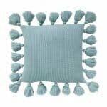 Image of teal knitted cushion cover with tassels
