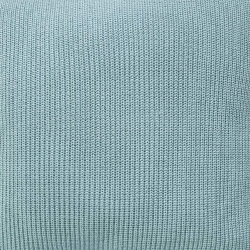 Close up photo of knitted cushion cover of teal colour