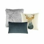 A set of 3 cushion covers with a grey fluffy cushion, a green rectangular cushion and a square cushion with a scandi moose design