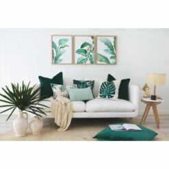 Tropical themed cushions and wall art against a white wall.