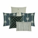 3 square cushions in grey, black and white a white knitted cushion cover and 1 black and white striped cushion cover.