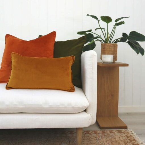 Gold, terracotta and olive velvet cushions on white sofa and against white wall