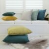 A collection of colourful velvet cushions on a clean, neutral background