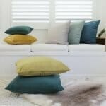 A collection of colourful velvet cushions on a clean, neutral background