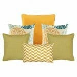 A set of six cushion covers including a single gold cushion cover, two paisley inspired design cushion covers, two square yellow cushions and a yellow and white rectangular cushion.
