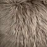 Close up image of light tawny brown square fur cushion