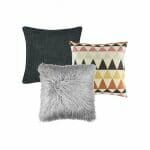 A set of three cushion covers with one charcoal cushion cover, one scandi design print cushion cover and one grey faux fur cushion cover.