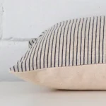 Lateral angle image of a designer rectangle cushion. The striped design is highlighted along its seams.
