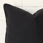A close up shot showing the top left side of this square linen cushion cover. The black tone is magnified.