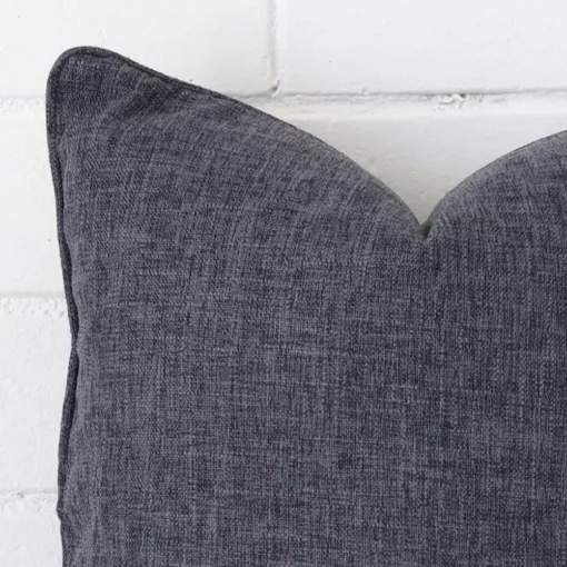 A close up image of this square cushion. The image shows details of its line fabric and charcoal colour.