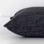 A charcoal cushion positioned on its back panel. The shot shows a lateral view of the linen fabric and its rectangle size.