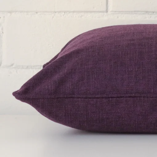 Side image of a linen square cushion cover. A close up of the purple colour.