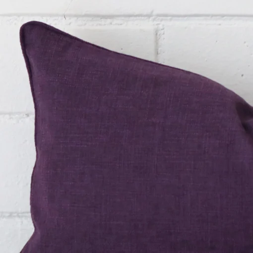 Macro image of a linen rectangle cushion cover. The shot shows the plum hue more clearly.