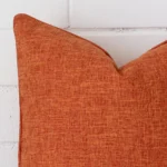 This image shows a rust cushion cover from a very close range. The square size and linen material is more clearly shown.