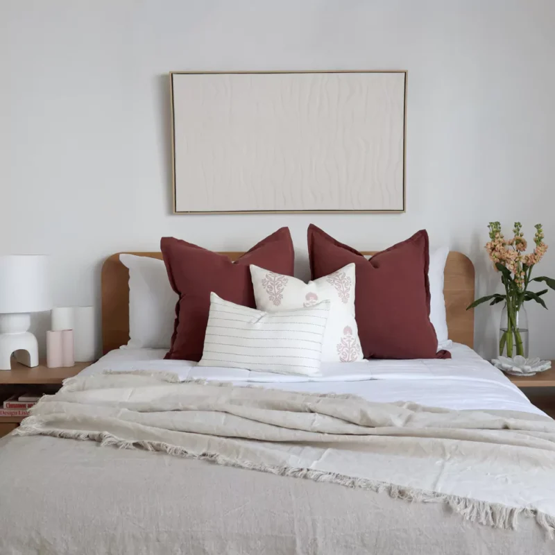 Above the Ali set of 4 bed cushions, a framed wall art decoration hangs elegantly.