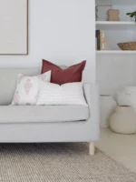 A light grey sofa adorned with three premium cushion covers from the set of 5 Ali sofa cushions.