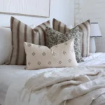 An image showing 4 designer bed cushions in a white-themed bedroom.