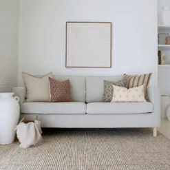 Three of the 5 designer cushions are neatly arranged on a gray sofa in perfect coordination.