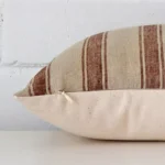 Enlarged image of the side of this designer cushion. The angle highlights how the rectangle design and striped decorative finish are joined along the seam.