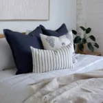 A side-view shot of the 4 Amelie bed cushions set next to a green plant.