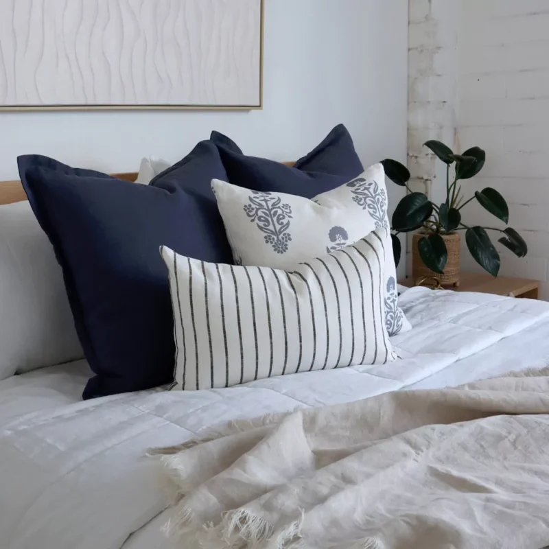 A side-view shot of the 4 Amelie bed cushions set next to a green plant.