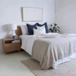 4 cushions from the Amelie bed set are arranged on a wooden bed adding a touch of beauty to the space.