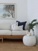 A light-coloured seat with three premium sofa cushion covers styled in the corner of it.