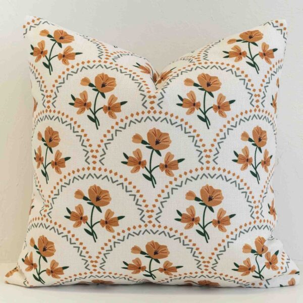 Amora floral scallop cushion with orange flowers and green geometric pattern.