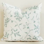 Cream cushion cover with soft sage green leaf branch print.