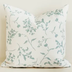 Cream cushion cover with soft sage green leaf branch print.