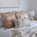 The bedroom gets a cozy touch with a set of four terracotta-hued cushions from the Aria bed cushion set.