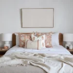 A bed featuring a wooden headboard, beautifully complemented by the Aria bed set of 4 cushions.