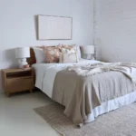 A white bedroom with wooden furnitures and the set of 4 Aria bed cushions.