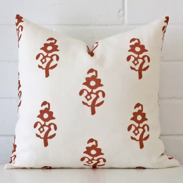 A bold patterned linen cushion in a sleek square size with a terracotta tone of colour.