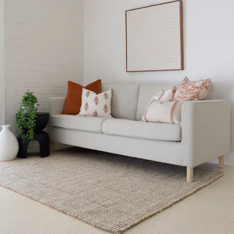 Adding a pop of warmth, terracotta-hued cushions from the Aria sofa cushion set collection of 5 grace a corner of the grey sofa.
