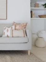 Terracotta-coloured cushions from the Aria sofa cushion set are displayed on a corner of a grey sofa.