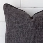 Extreme close up of a square grey cushion. The linen fabric is shown with a much higher degree of detail.