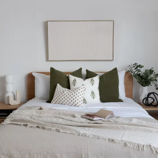 The olive-coloured bed cushions placed beside a green plant create a natural vibe.