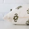 Side image of a linen rectangle cushion cover. The design and olive green colour are visible from the side showing the attachment of the panels.