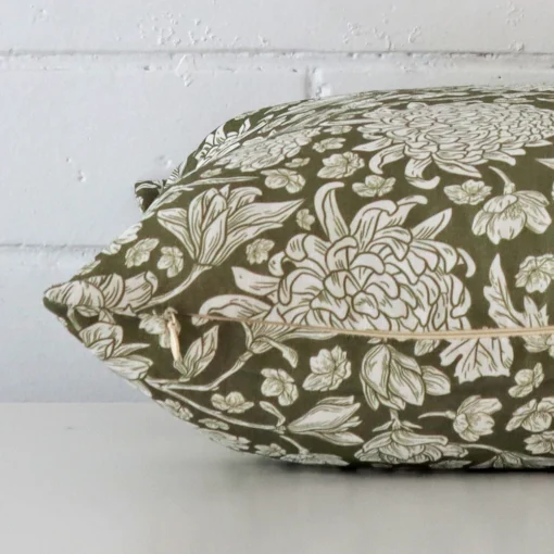 Side shot showing the seam of this square olive green cushion that features a floral motif on its linen material.