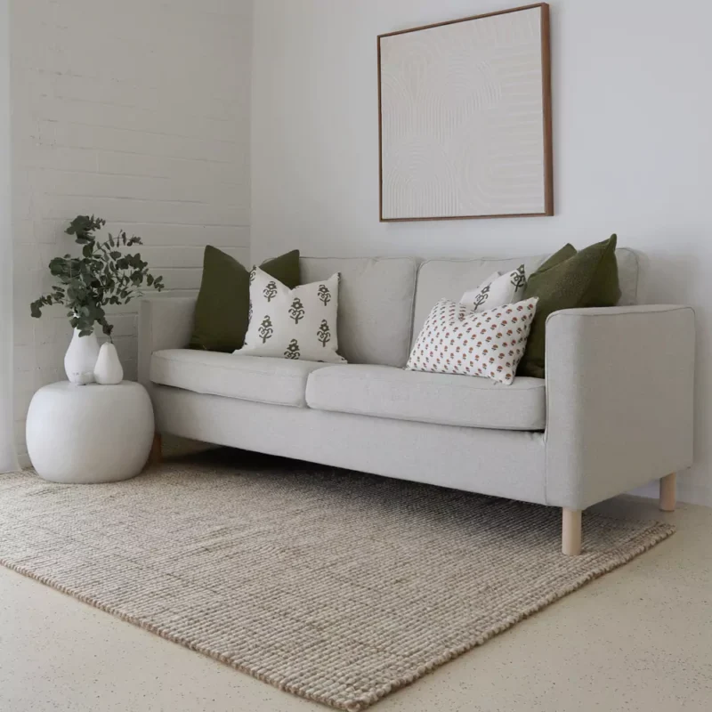 A set of 5 Ava sofa cushions are neatly arranged on a grey sofa in perfect coordination.
