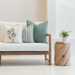 A set of 3 avena outdoor cushions sitting on a white couch.
