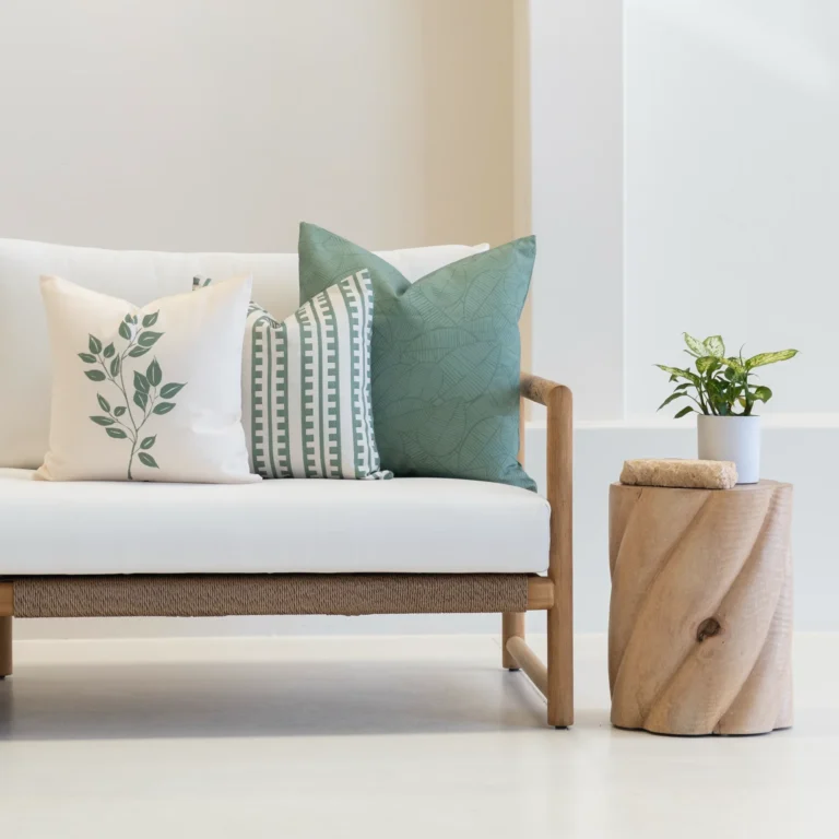 A set of 3 avena outdoor cushions sitting on a white couch.