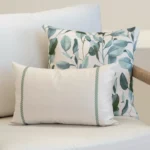 A set of 2 Avena outdoor cushions on a white sofa in an outdoor seating.