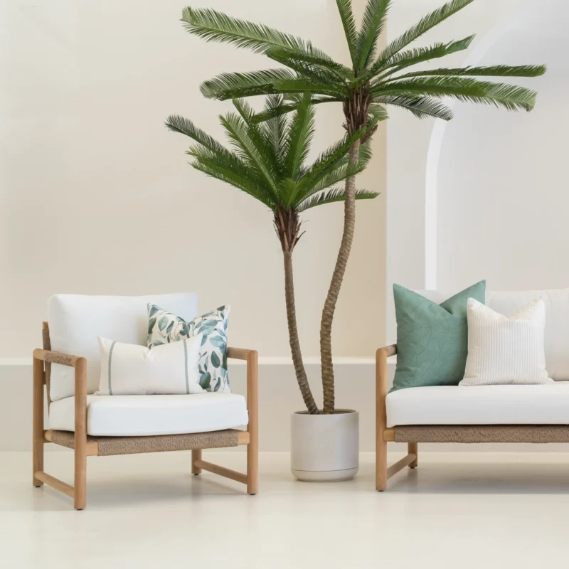 4 outdoor couch cushions from the Avena set are tucked in the corner of a white sofa.