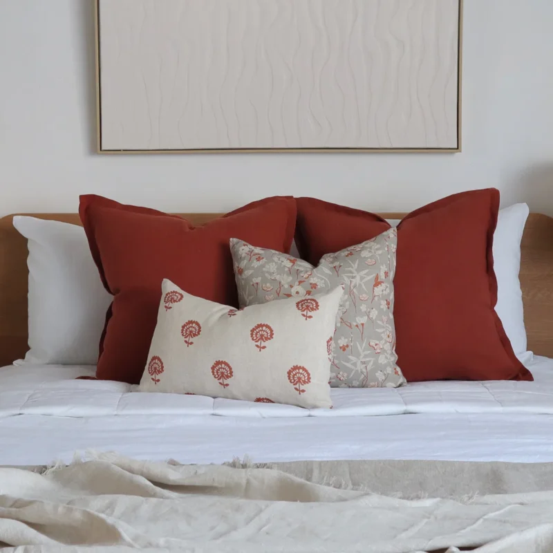 The set of 4 Avery bed cushions adds warmth to the bedroom with white-painted walls.
