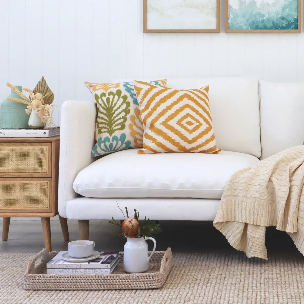 A beach style room with two coastal cushions.