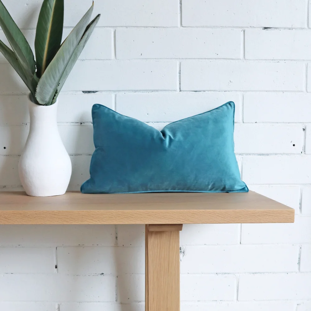 A blue velvet cushion on a bench seat.